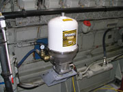 Spinner II centrifuge mounted on the side of a diesel engine